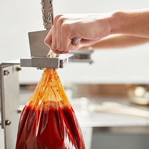 Cook Chill bag filled with marinara sauce, securely sealed with clips and clippers for safe storage and reheating.